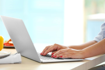 Girl with laptop on kitchen. Food blogger concept