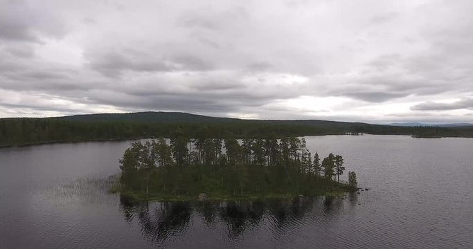 Aerial view of a small remote island in a scandinavian lake, slow flight