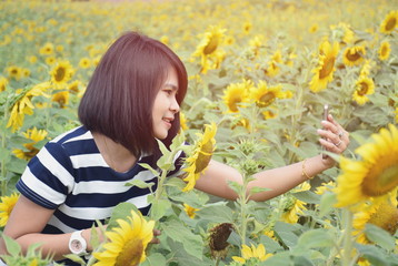 Beautiful girl making selfie photo on smartphone with sunflower background