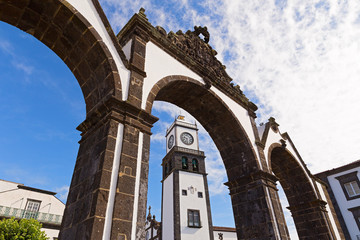 The historical entrance (Portas da Cidade) to the village of Ponta Delgada in Azores, Portugal. Entrance gates and the clock tower of Saint Sabastian church.