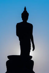 Silhouette Buddha with sunset and blue sky background