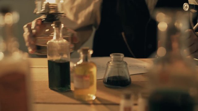 turn of the century scientist or pharmacist moves a lamp closer to the microscope 