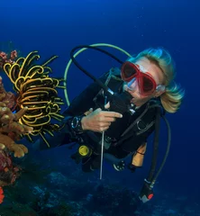 Fotobehang Woman scuba diver exploring coral reef © Richard Carey