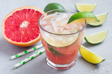 Cold pink cocktail with fresh grapefruit, lime and ice cubes