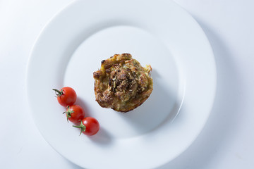 Zucchini muffin and cherry tomato in white plate