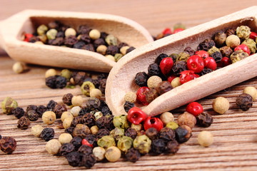 Fresh colored pepper with spoon on wooden background