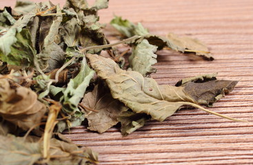 Heap of dried lemon balm on wooden surface
