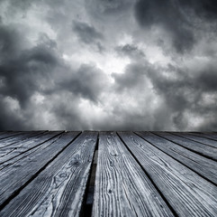 Naklejka na ściany i meble Rostrum made of wooden planks on stormy sky