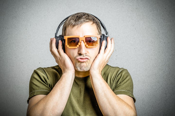 Junger Mann hört Musik und trägt Sonnenbrille