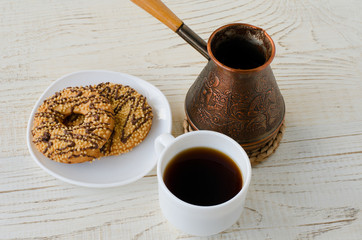Top view of a cup of coffee, cookies and a coffee pot