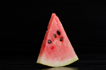 Triangle ripe watermelon on a black background
