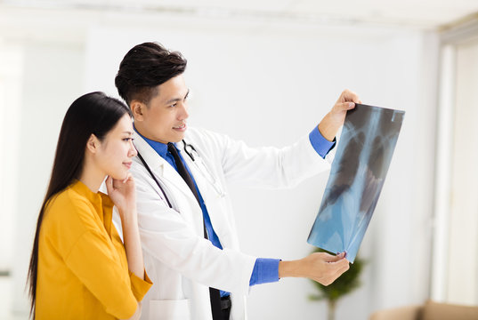  young doctor looking at patient's x-ray film