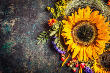 Sunflowers with berries and flowers. Floral autumn decoration on dark rustic vintage background, top view, border © VICUSCHKA