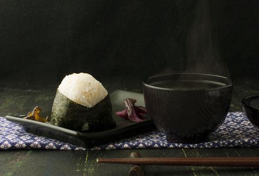 rice ball onigiri and miso soup on a dark background