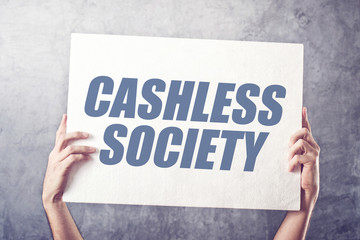 Hands holding banner with Cashless society title