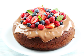 Homemade chocolate cake with berries on white wooden table