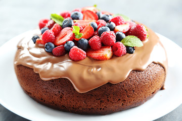 Homemade chocolate cake with berries on grey wooden table