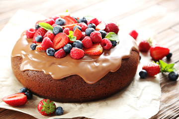 Homemade chocolate cake with berries on brown wooden table
