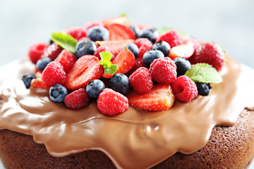Homemade chocolate cake with berries on grey wooden table