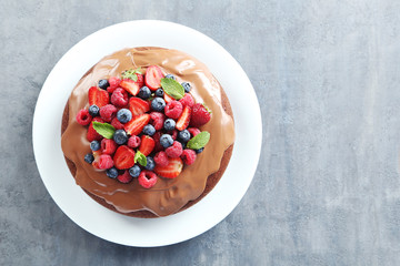 Homemade chocolate cake with berries on grey wooden table