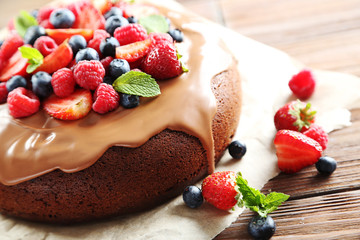 Homemade chocolate cake with berries on brown wooden table