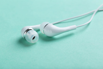 White headphones on a mint paper background