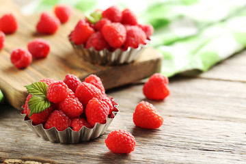 Red raspberries in bowl on a grey wooden table