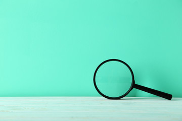 Magnifying glass on a green wooden table