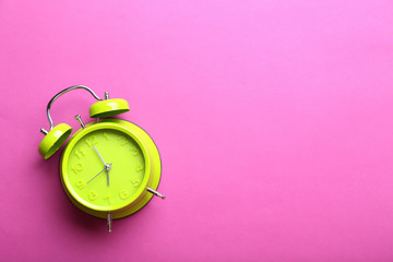 Green alarm clock on a pink background