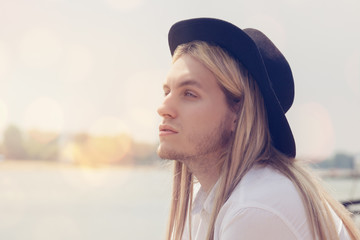 Portrait of a young hipster man at the beach

