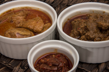 Beef Rendang, chicken curry and sambal in ramekin