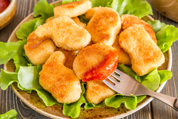 Chicken nuggets with ketchup.