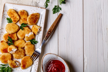Chicken nuggets with ketchup.