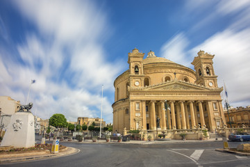 Obraz premium Mosta, Malta - The Church of the Assumption of Our Lady, commonly known as the Rotunda of Mosta or Mosta Dome at daylight with moving clouds