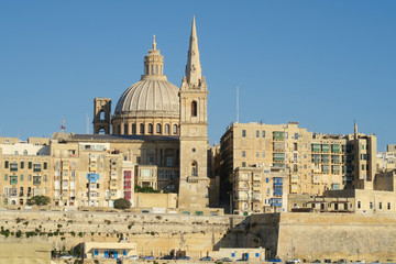 Fototapeta na wymiar Valletta, Malta. View of Basilica of Our Lady of Mount Carmel. One of three cathedrals of the Anglican Diocese of Gibraltar in Europe St Paul's Pro-Cathedral tower is also visible.