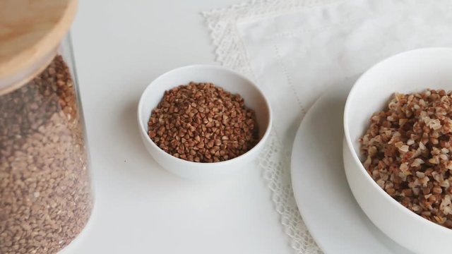 Cooked buckwheat groats with butter and mug of milk on a table 