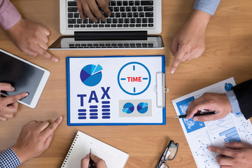 TAX TIME   Business team hands at work with financial reports