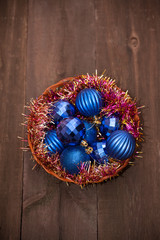 blue Christmas balls in a basket on a wooden background