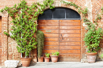 Fototapeta na wymiar Old Wooden door and flowers in Tuscany, Italy