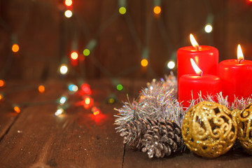 three burning candles and golden balls. christmas background
