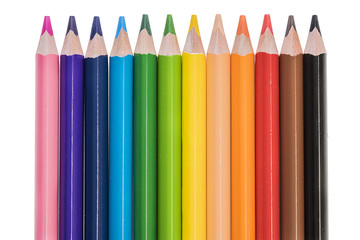 Colored pencils in row over white background