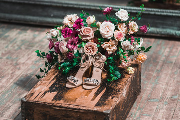 Bride shoes with jewels and surrounded by flowers arrangement