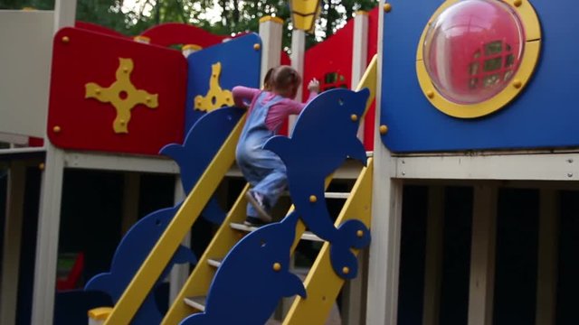 Redhead Little Girl Plays On Playground