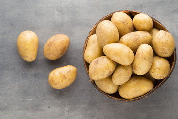 New potato on the bowl, gray background.