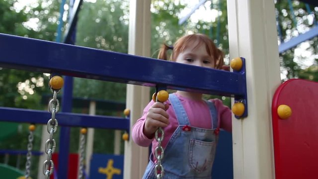 Redhead Little Girl Plays On Playground