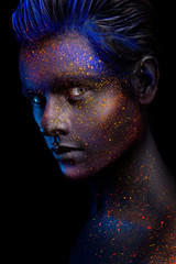 Glowing neon makeup with dramatic look in his eyes. Creative body art on the theme of space and...