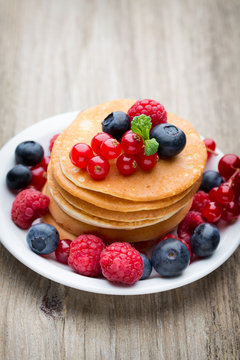 Stack of pancakes with blueberry and fresh berry.