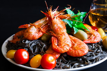 Food. black pasta, shrimps, cherry tomatoes, white wine, black b