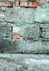 Old wall rom a brick and building blocks with the spots of cement. Background