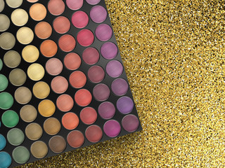 eye shadow palette on gold glitter background